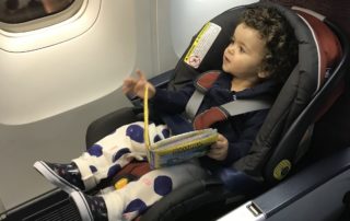 Cadeirinha e bebê conforto no assento do avião